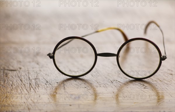 Close up antique round glasses on wooden table.