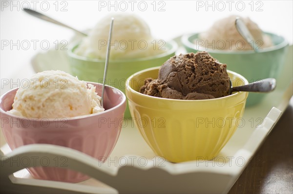 Close up of bowls with ice cream selection on tray.