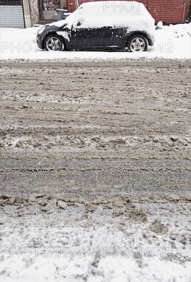 USA, New York State, Brooklyn, Williamsburg, tire tracks on snow covered street. Photo : Jamie Grill Photography