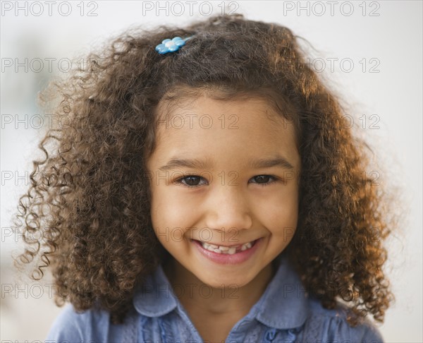 Portrait of smiling girl (6-7) with afro.