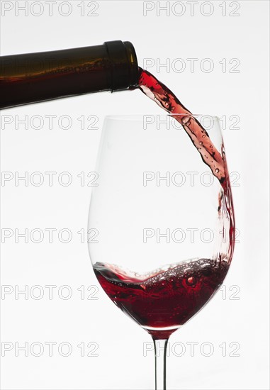 Close up of red wine being poured into wine glass.
