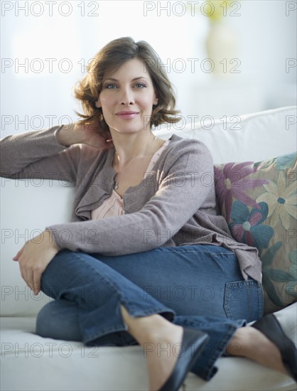 Portrait of woman sitting on sofa.