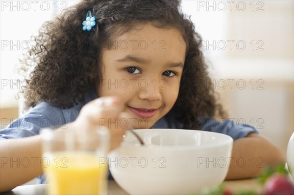 Girl (6-7) eating breakfast.