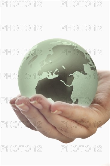 Studio shot of woman holding glass globe model.