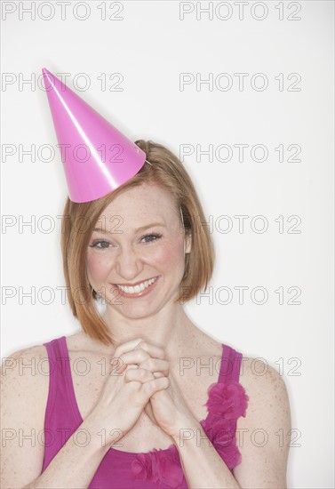 Portrait of woman wearing pink party hat.