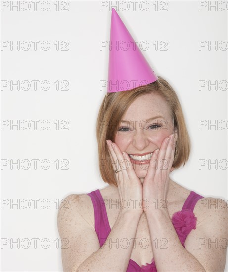 Portrait of woman wearing pink party hat.