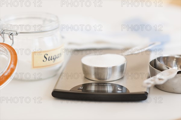 Spoon of sugar on weight scale.