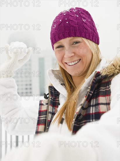 Young woman throwing snowball. Photo : Jamie Grill Photography