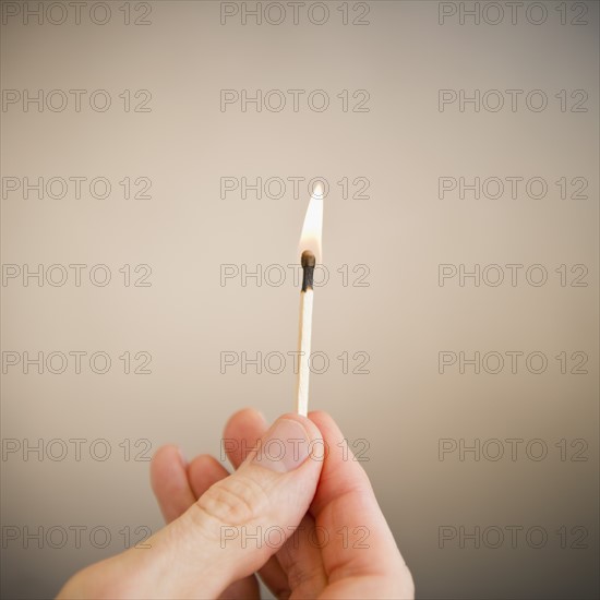 Hand holding match. Photo : Jamie Grill Photography