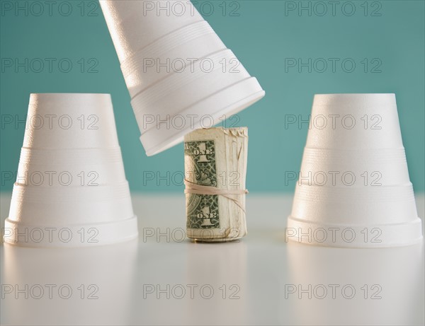 Studio shot of money under cup. Photo : Jamie Grill Photography