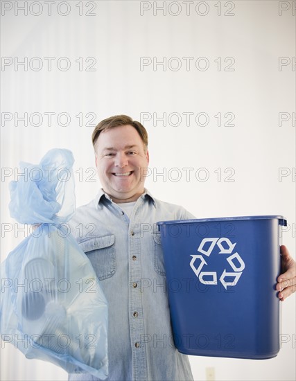 Man holding bag and recycling bin. Photo : Jamie Grill Photography