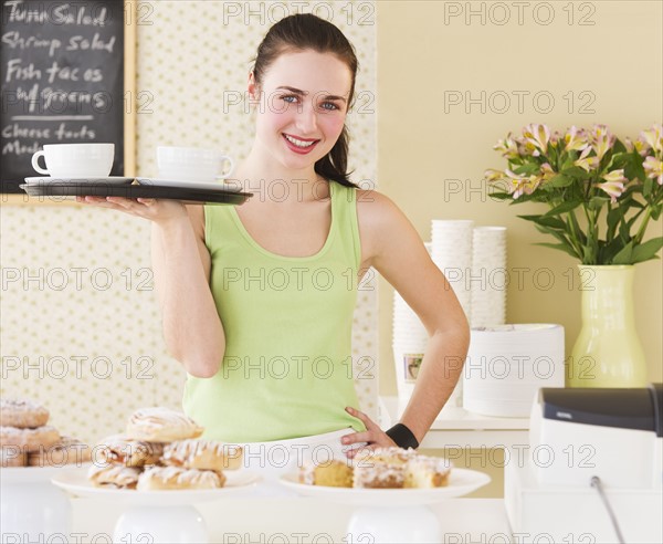 Portrait of waitress holding tray. Photo: Daniel Grill