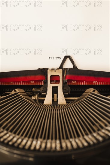 Close up of antique typewriter with "the end" print on page.