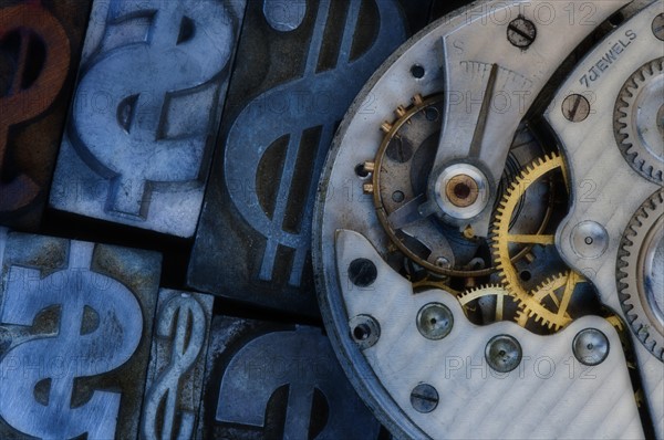 Close up of clock mechanism and dollar sign.