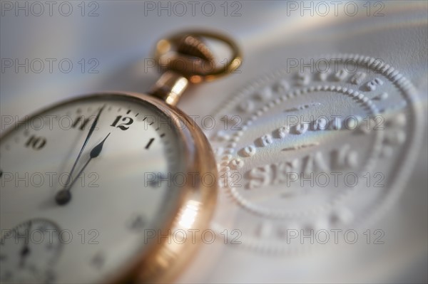 Close up of pocket watch and corporate seal.