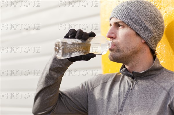 Man in workout wear drinking water. Photo: Take A Pix Media