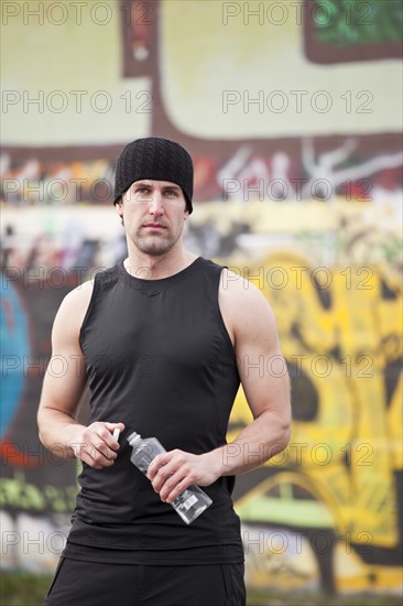 USA, Washington, Seattle, man in workout wear in front of graffiti wall. Photo : Take A Pix Media