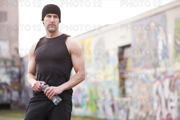 USA, Washington, Seattle, man in workout wear in front of graffiti wall. Photo : Take A Pix Media