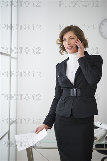 Businesswoman talking on mobile in office.