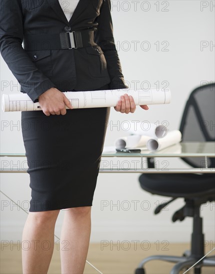 Close up of businesswoman's hands holding paper roll.