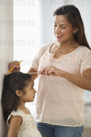 Mother measuring daughter (6-7).