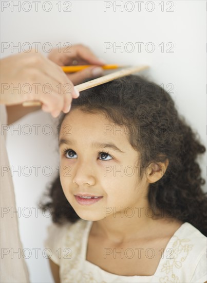 Mother measuring daughter (6-7).