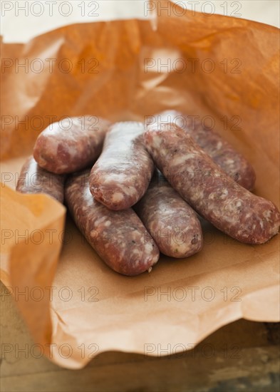 Studio shot of sausage wrapped in brown paper.