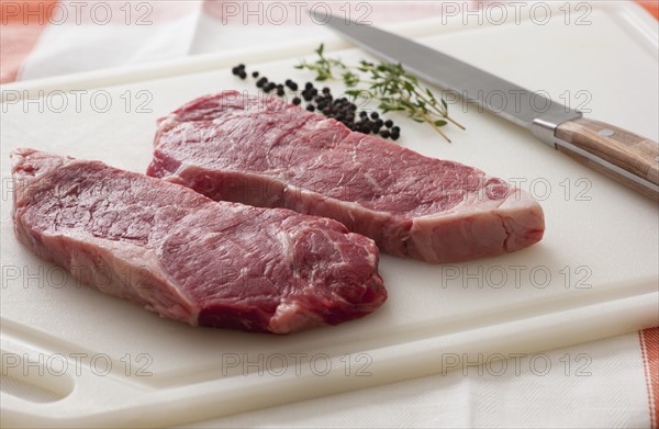 Studio shot of raw steak on chopping board.