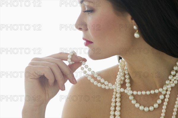 Profile of young woman wearing pearls.