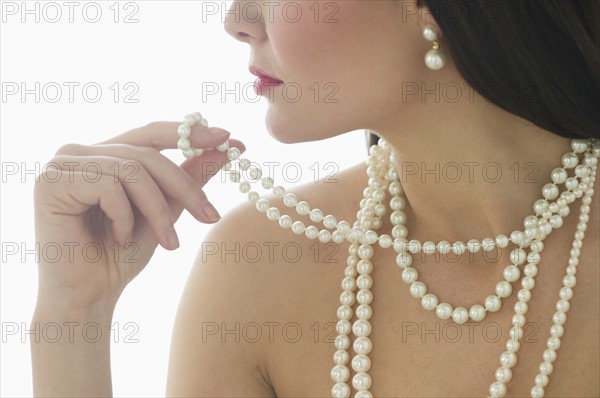 Profile of young woman wearing pearls.