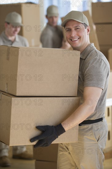 Men sorting boxes in warehouse.