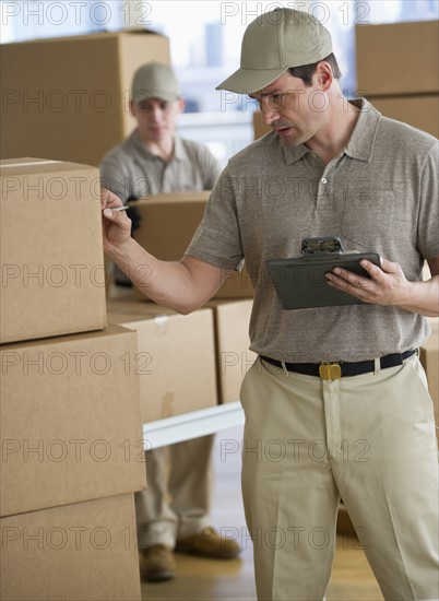 Man checking checklist in warehouse.