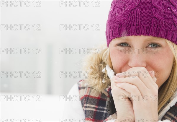 Jersey City, New Jersey, woman wearing warm clothing clasping hands. Photo : Jamie Grill Photography