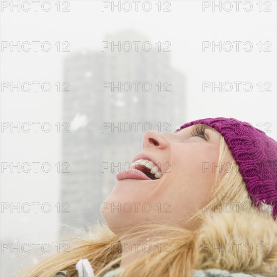 USA, New Jersey, Jersey City, woman catching snowflakes with tongue. Photo: Jamie Grill Photography