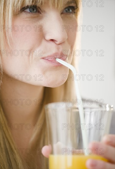 Young woman drinking juice. Photo : Jamie Grill Photography