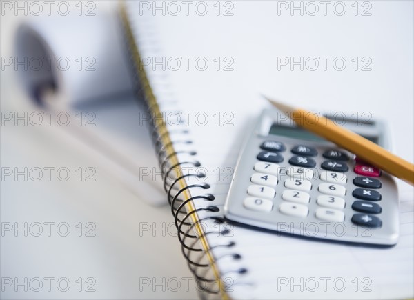 Studio shot of calculator and pencil on notebook. Photo : Jamie Grill Photography