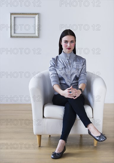 Portrait of woman sitting in armchair. Photo : Daniel Grill