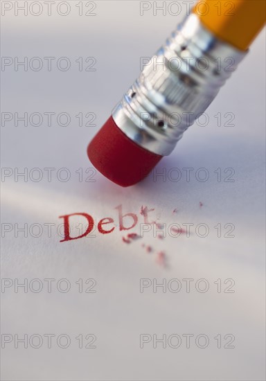 Studio shot of pencil erasing the word debt from piece of paper. Photo : Daniel Grill