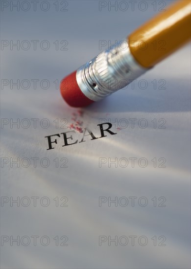 Studio shot of pencil erasing the word fear from piece of paper. Photo : Daniel Grill