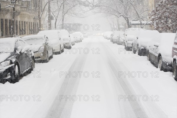 USA, New York City, snowy street with rows of parked cars. Photo: fotog