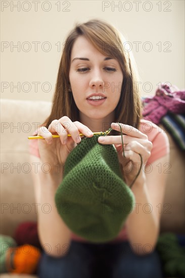 Young woman knitting woolly hat. Photo: Mike Kemp