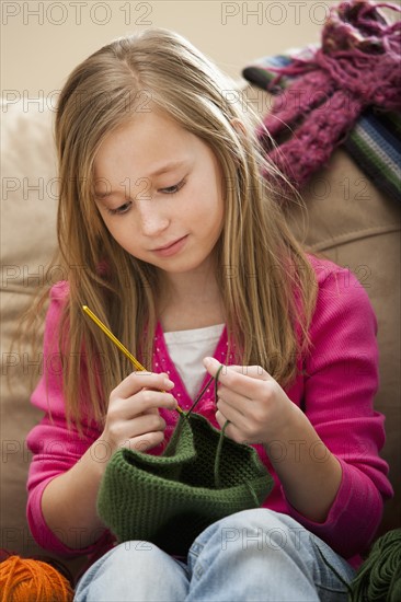 Girl (8-9) knitting woolly hat. Photo : Mike Kemp