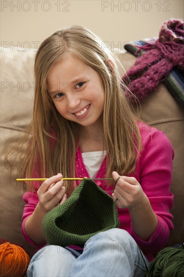 Girl (8-9) knitting woolly hat. Photo : Mike Kemp