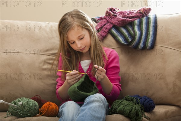 Girl (8-9) knitting woolly hat. Photo : Mike Kemp