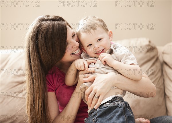 Mother playing with son (2-3) on sofa. Photo: Mike Kemp