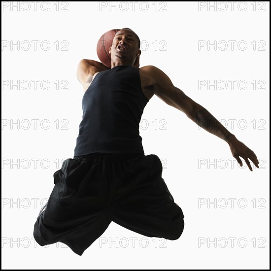 Studio shot of young man playing basketball. Photo: Mike Kemp