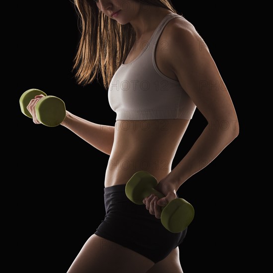 Young woman using hand weights. Photo: Mike Kemp