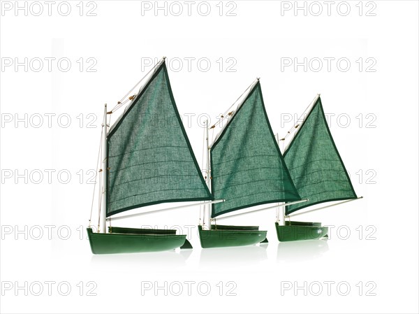 Row of toy boats on white background. Photo : David Arky