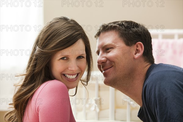 Young pregnant woman about to be kissed by mid adult man. Photo : Mike Kemp