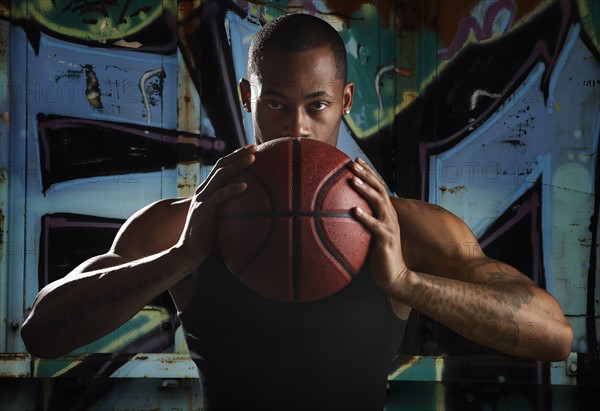 Portrait of young man with basketball. Photo : Mike Kemp